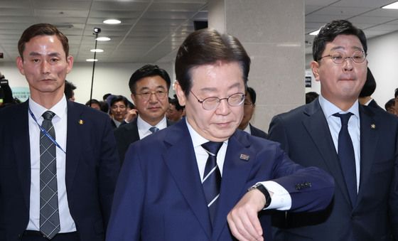 손목 시계 바라보며 소통관 나서는 이재명