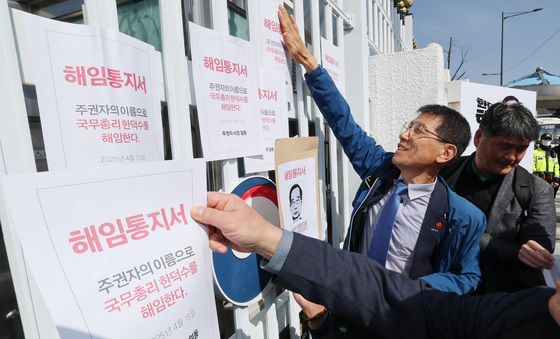 정부서울청사 담벼락에 한덕수 해임통지서 붙이는 시민들