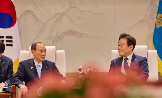 대화 나누는 이재명 대통령·스가 전 일본총리
