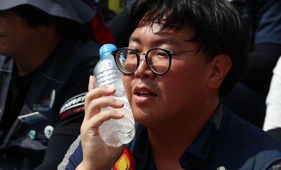 뜨거운 아스팔트 바닥에서 열기 식히는 노동자