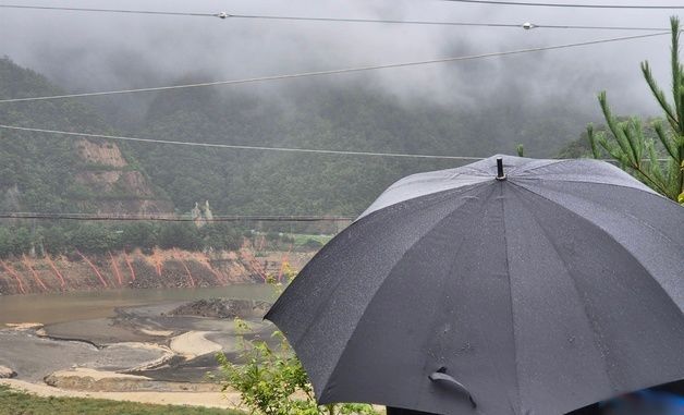우산 쓰고 오봉저수지 바라보는 강릉시민
