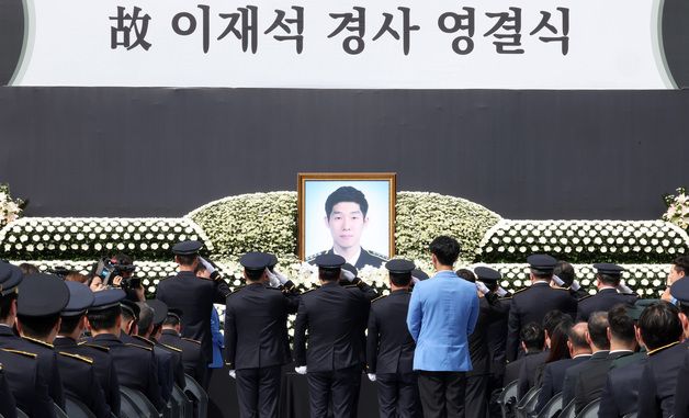 헌화 후 경례하는 동료 경찰들