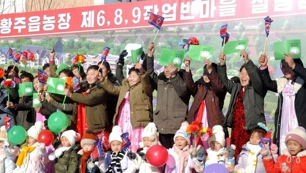 새집들이 행사에서 인공기 흔들며 기뻐하는 北 주민들