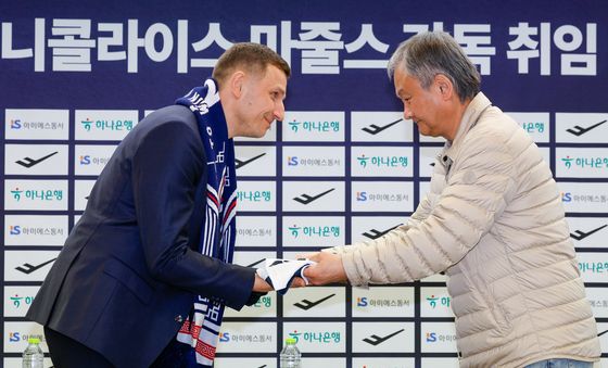 니콜라이스 마줄스 감독에게 유니폼 전달하는 유재학 본부장