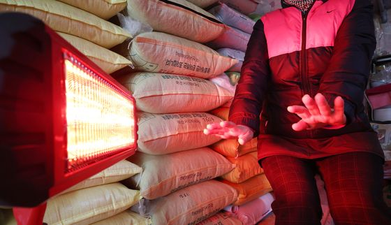 난로에 손 쬐는 시장 상인들