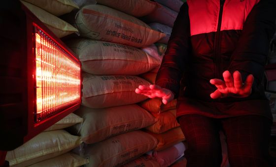 난로에 손 쬐는 시장 상인들