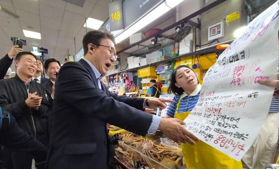 자갈치시장 상인에게 응원 보드 받는 김민석 대표