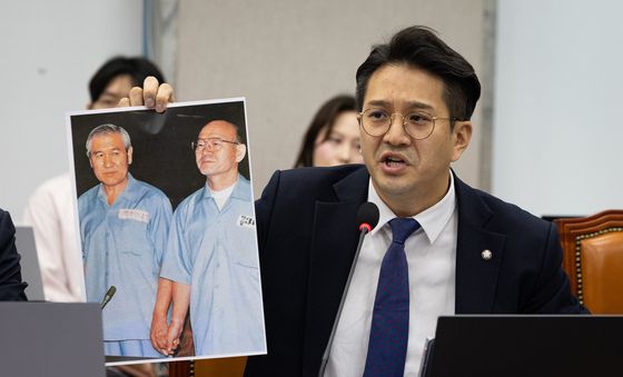 수의 입은 노태우·전두환 사진 든 전용기 의원