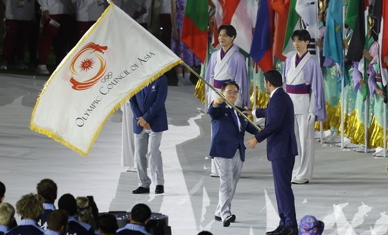 OCA 회장에게 대회기 전달하는 오무라 히데아키 위원장