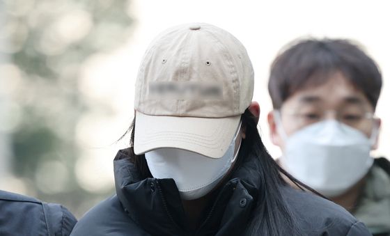'약물 든 음료로 남성 살해' 고개 숙인채 출석하는 20대 여성