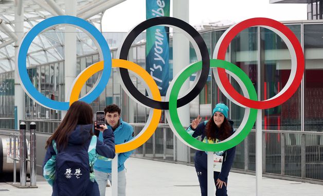 오륜기 앞에서 추억 남기는 자원봉사자들