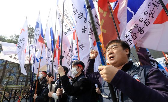 깃발 휘날리며 구호 외치는 노동조합원들