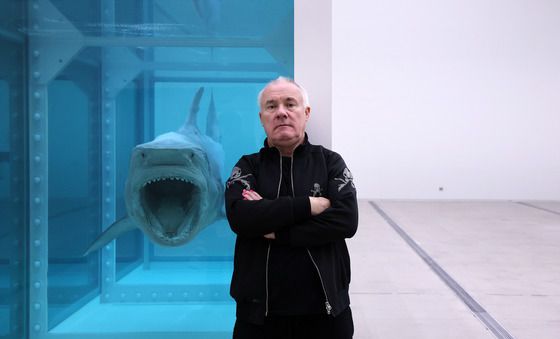 대표작 앞에서 포즈 취하는 데이미언 허스트