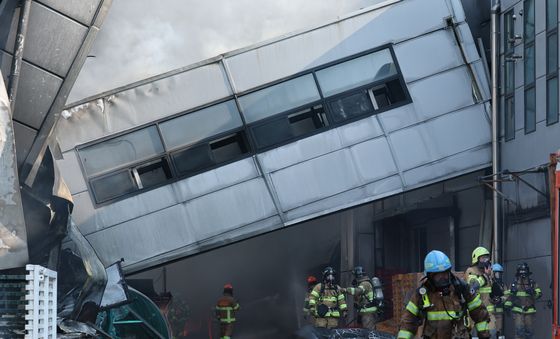 붕괴된 건물 아래서 화재 진화