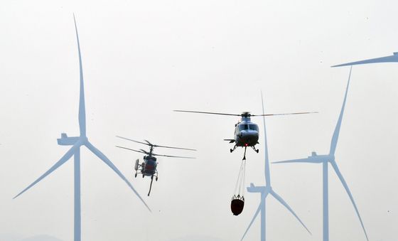 풍력발전기 사이로 비행하는 진화헬기