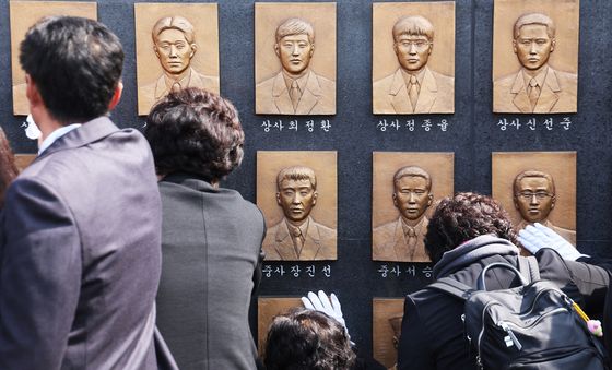 추모비 어루만지는 유가족