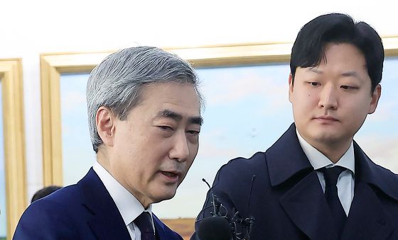 마이크 들어 올려 답하는 신현송 후보자