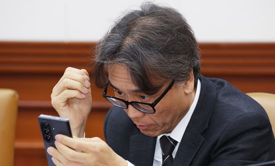 휴대폰 바라보는 금한승 차관