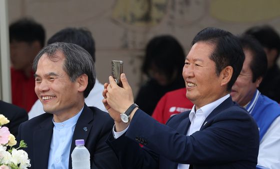 핸드폰 카메라 들고 미소 보이는 정청래 대표