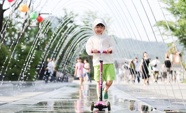 무더위 속 물줄기 사이 달리는 어린이