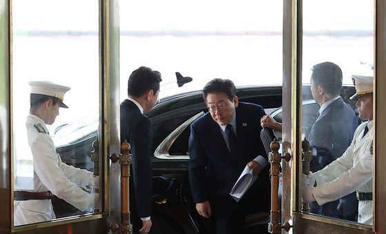 국무회의 자료 들고 차량에서 내리는 이재명 대통령