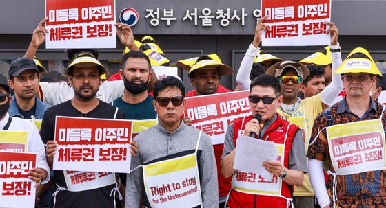 미등록 이주민 체류권 보장 촉구 피켓 든 이주민들