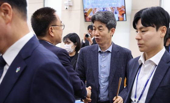 악수하는 투표용지 부족사태 국조특위 여야 간사
