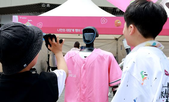 로봇과 인사 나누는 어린이들