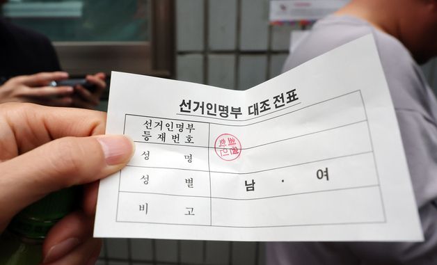선거인명부 대조 전표 들어보이는 유권자