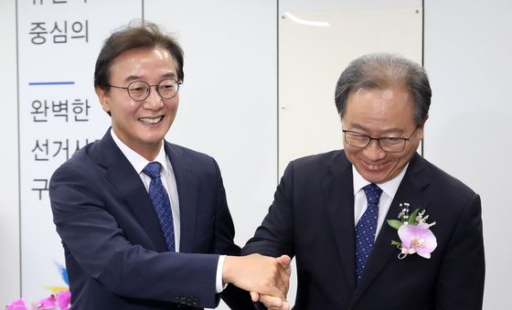 악수하는 전재수 부산시장 당선인과 김석준 부산시교육감 당선인