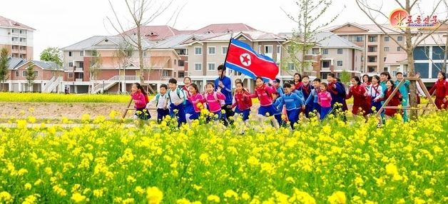 유채꽃밭을 걷는 북한 어린이들…신의주온실농장 조명한 北