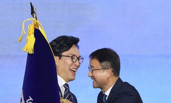 당기 건네 받는 김민석 신임 대표