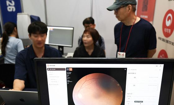 '망막 AI 분석기 체험하는 관람객들'