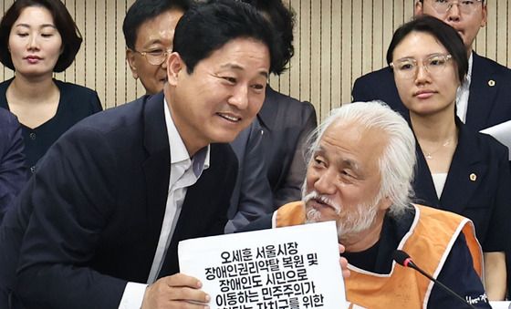손 맞잡은 전장연·서울시의회 민주당