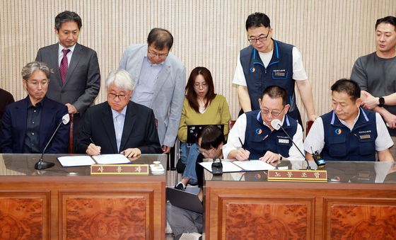 조정안에 서명하는 김정환 이사장과 박점곤 위원장 '극적 타결'