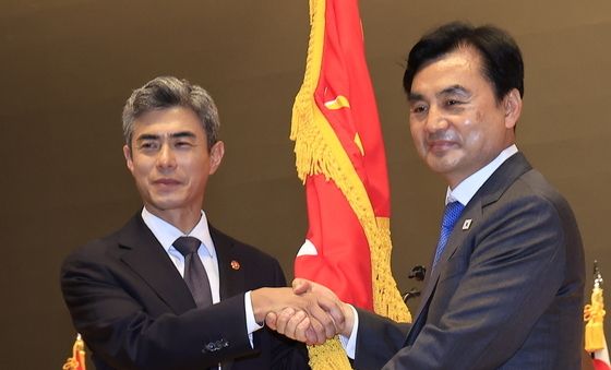 악수하는 강신철 신임 국방장관과 안규백 전 장관