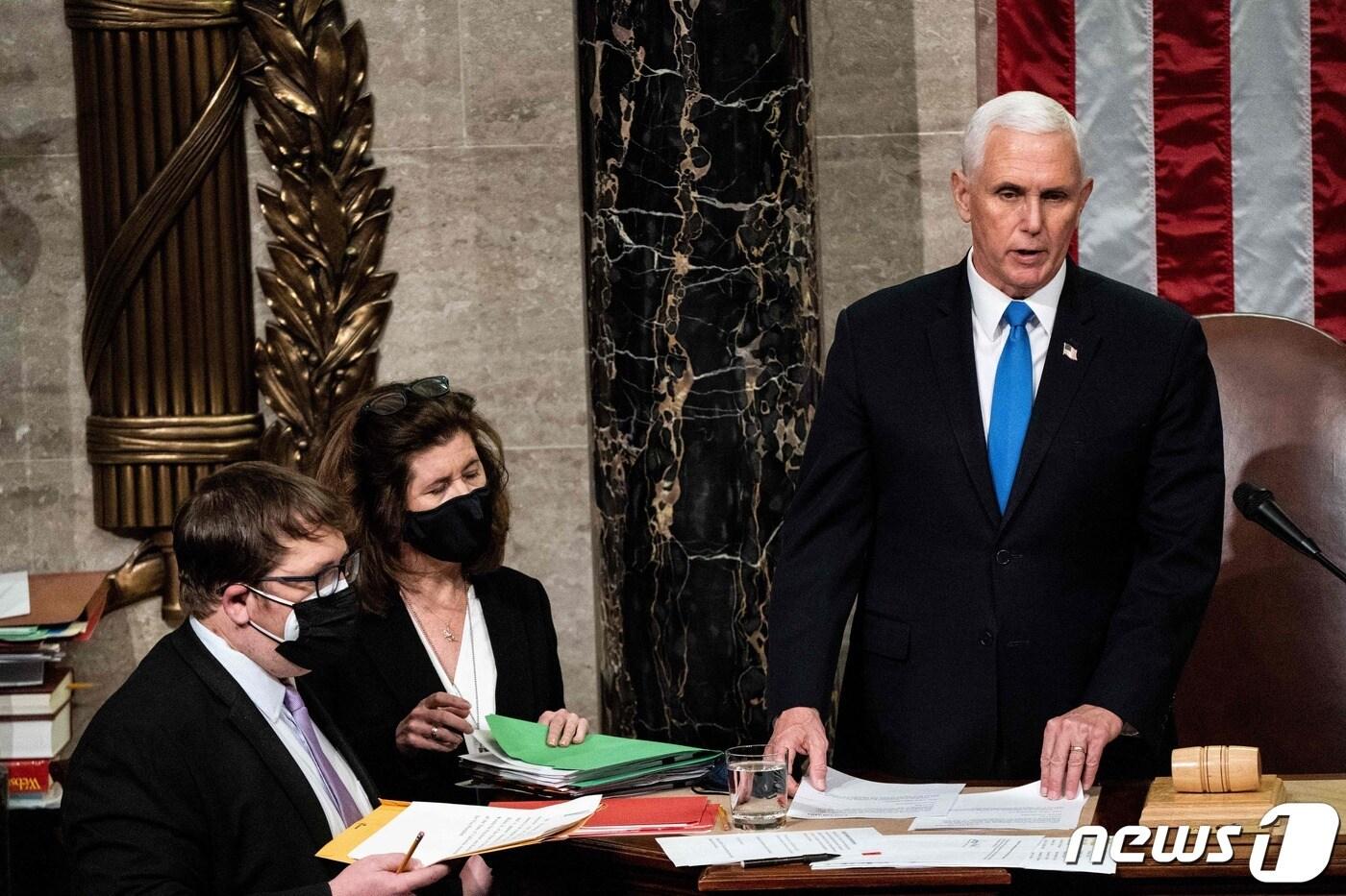 마이크 펜스 당시 미국 부통령이 2021년 1월 6일(현지시간) 워싱턴 의사당에서 도널드 트럼프 대통령 지지자들의 의회 난입사태로 중단됐던 조 바이든 대통령 당선인의 승리를 인증하는 상·하원 합동회의를 주재하고 있다. ⓒ AFP=뉴스1 ⓒ News1 우동명 기자