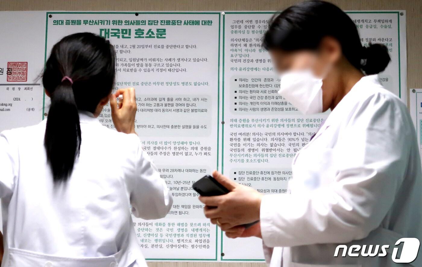 정부의 의대정원 확대 정책에 반발하는 전공의 단체행동이 8일째 이어진 27일 오후 서울의 한 대학병원에서 한 의사가 '의대 증원을 무산시키기 위한 의사들의 집단 진료중단 사태에 대한 대국민 호소문'을 바라보고 있다. 2024.2.27/뉴스1 ⓒ News1 장수영 기자