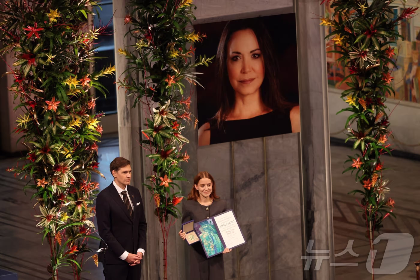 2025년 노벨평화상 수상자인 마리아 코리나 마차도의 딸 아나 코리나 소사가 10일(현지시간) 노르웨이 오슬로에서 열린 노벨평화상 시상식에서 마리아를 대신해 노벨평화상을 수상하고 있다. 2025.12.10 ⓒ 로이터=뉴스1 ⓒ News1 김경민 기자