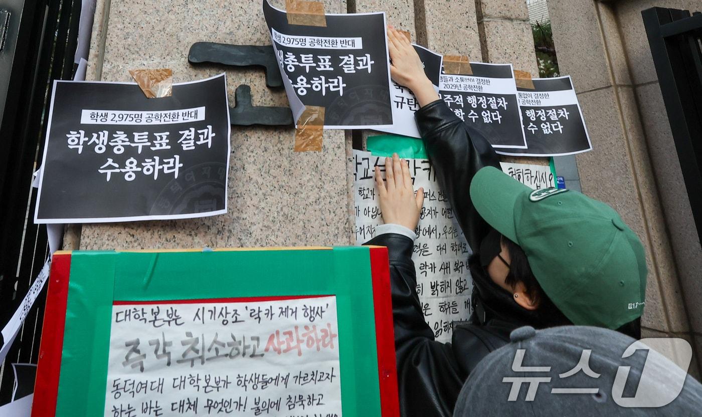 동덕여자대학교 학생들이 9일 오후 서울 성북구 동덕여대 정문 앞에서 제58대 총학생회 비상대책위원회·중앙운영위원회 주최 '공학전환에 대한 8000 동덕인 총투표 결과 전달 기자회견'을 마친 뒤 공학 전환 반대 손팻말을 정문에 붙이고 있다. ⓒ News1 안은나 기자