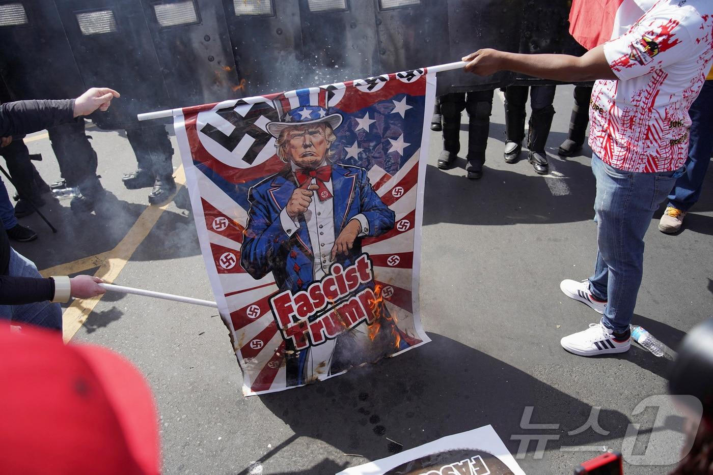 마르코 루비오 미국 국무장관이 호세 라울 물리노 대통령과 파나마 운하와 이민을 논의하기 위해 방문을 한 가운데, 2일(현지시간) 파나마시티에서 군중이 도널드 트럼프 미국 대통령이 그려진 깃발을 태우는 시위를 벌이고 있다. ⓒ 로이터=뉴스1 ⓒ News1 류정민 특파원