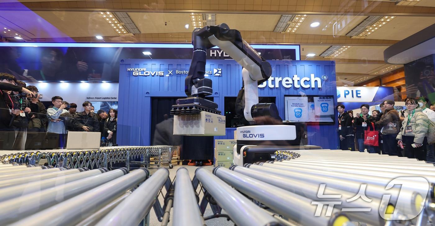 지난 3월12일 서울 강남구 코엑스에서 열린 2025 스마트공장·자동화산업전를 찾은 관람객들이 현대 글로비스 부스에서 보스턴다이내믹스가 개발한 물류 로봇 '스트레치' 시연을 관전하고 있다. 2025.3.12/뉴스1 ⓒ News1 김성진 기자