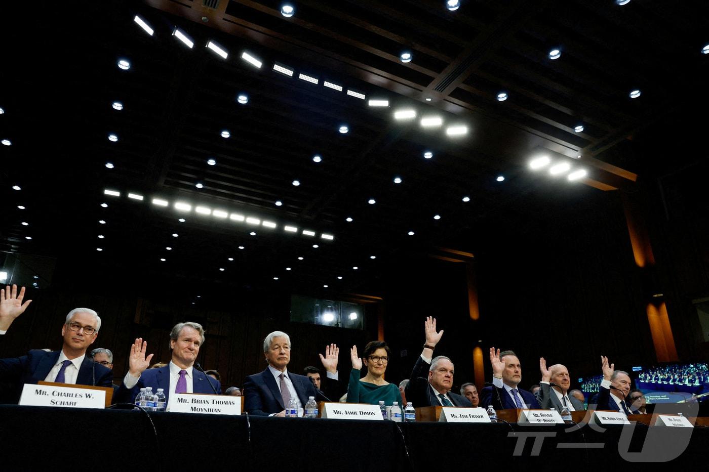 왼쪽부터 △웰스파고 CEO 겸 사장 찰스 W. 샤프 △뱅크오브아메리카 회장 겸 CEO 브라이언 토마스 모이니한△JP모간체이스 회장 겸 CEO 제이미 다이먼 △씨티그룹 CEO 제인 프레이저 △스테이트 스트리트 CEO 로날드 오핸리 △BNY 멜론 CEO 로빈 빈스 △골드만 삭스 CEO 데이비드 솔로몬 △모간스탠리 회장 겸 CEO 제임스 고먼이 2023년 12월 6일 미국 워싱턴 의사당에서 열린 월스트리트 기업들에 대한 미국 상원 은행주택도시문제위원회 청문회에서 손을 들고 있다. 2023.12.6 ⓒ 로이터=뉴스1 ⓒ News1 강민경 기자