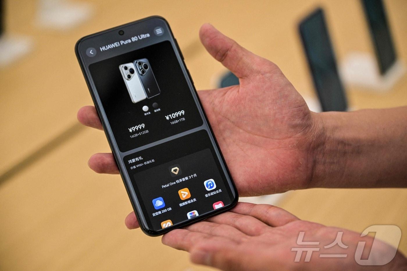 화웨이 직원이 23일 상하이 황푸 지역에 위치한 화웨이 상하이 플래그십 스토어에서 새로운 화웨이 푸라 80 울트라 스마트폰을 선보이고 있다. 2025.6.23 ⓒ AFP=뉴스1 ⓒ News1 강민경 기자