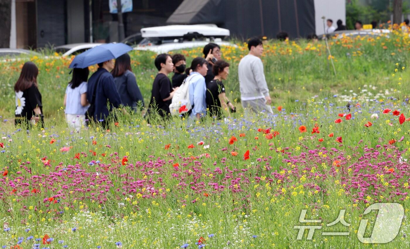 초여름 날씨를 보인 7일 서울 종로구 열린송현공원에서 시민들이 꽃밭을 걸으며 나들이를 하고 있다. 기상청은 당분간 전국 대부분 지역의 낮 기온이 25도 이상으로 오르고, 특히 내륙은 30도 이상으로 오른다고 예보했다. 2025.6.7/뉴스1 ⓒ News1 김명섭 기자