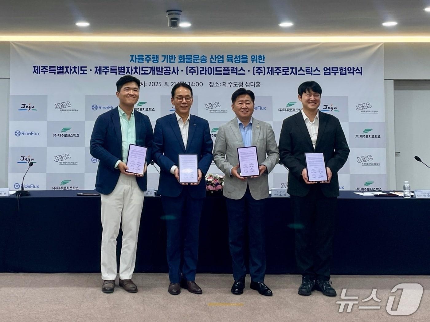 본문 이미지 - (왼쪽부터)조화현 제주로지스틱스 대표, 백경훈 제주특별자치도개발공사 사장, 오영훈 제주특별자치도지사, 박중희 라이드플럭스 대표가 21일 제주도청에서 열린 '제주삼다수 유상 자율주행 화물운송 실증사업'을 위한 상호협력 업무협약식에 참석해 기념촬영을 하고 있다.(라이드플럭스 제공)