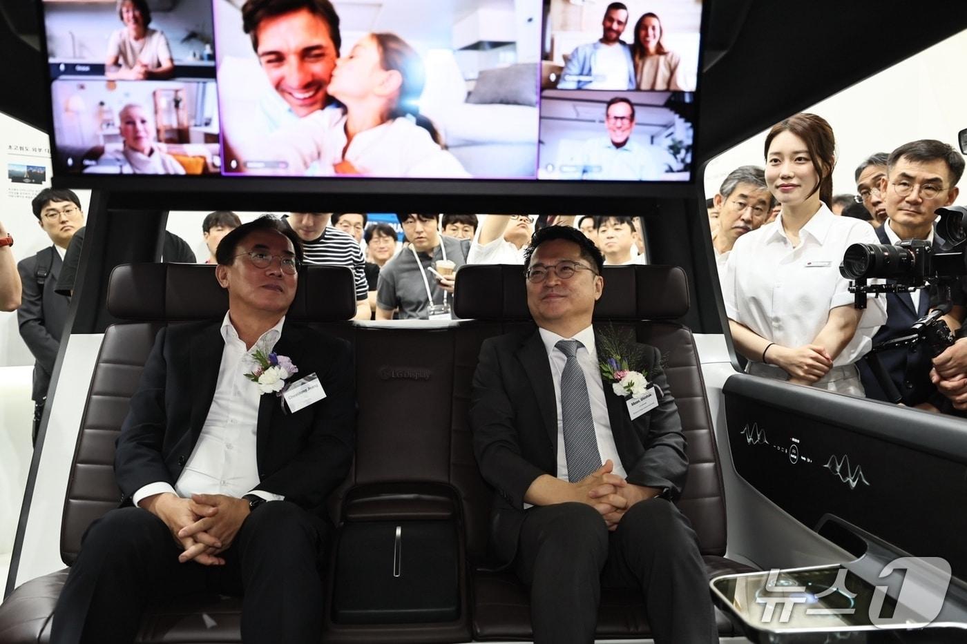 정철동 LG디스플레이 사장(왼쪽)과 문신학 산업통상자원부 차관이 7일 서울 코엑스 LG디스플레이 부스에서 소프트웨어 중심 차량(SDV)을 본 딴 콘셉트카에서 전장용 OLED 기술을 체험하고 있다. 2025.8.7/뉴스1 최동현