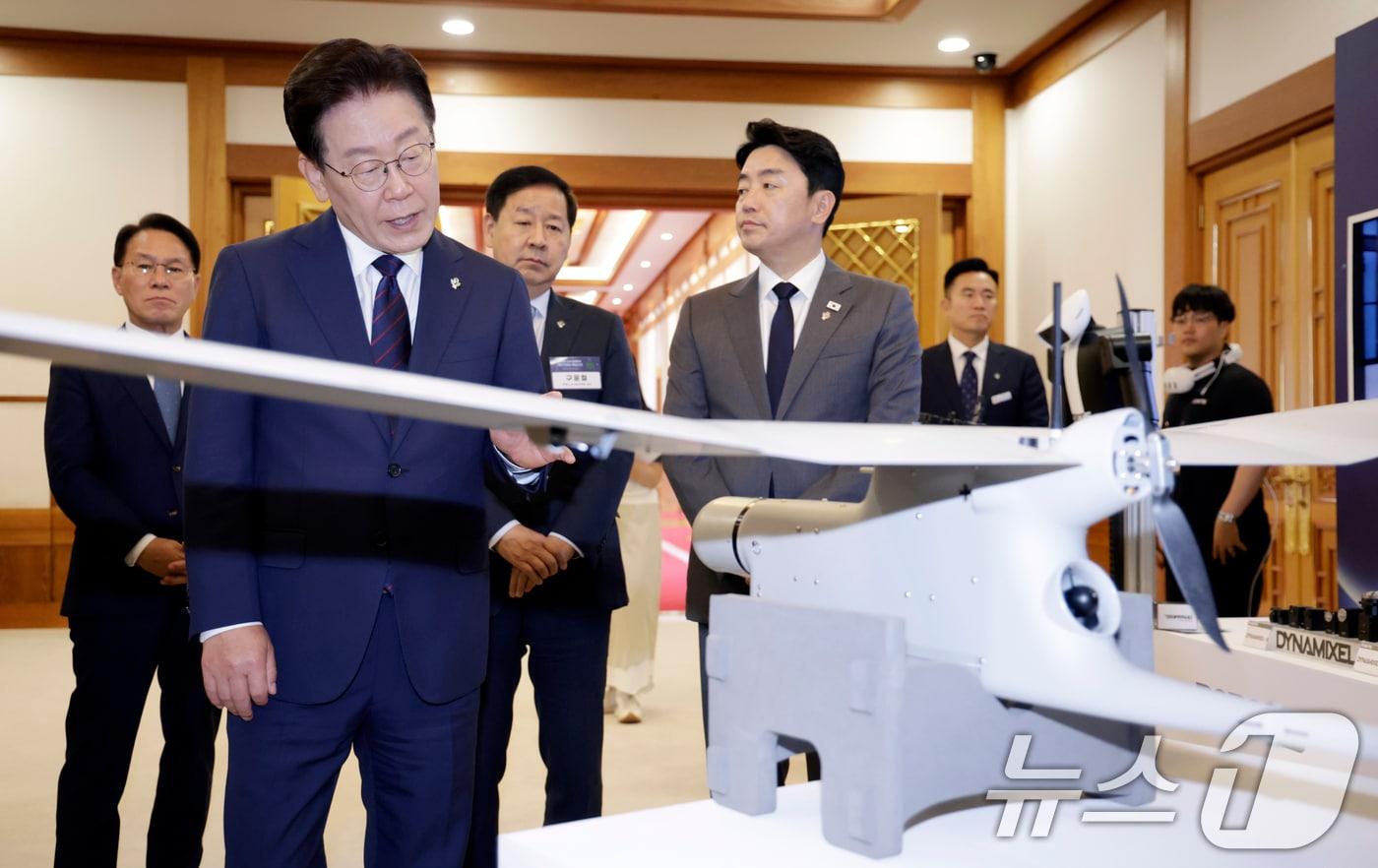 본문 이미지 - 이재명 대통령이 26일 청와대에서 열린 미래 新안보 혁신기업 육성 전략회의에 참석하며 정찰용 무인항공기를 살펴보고 있다. 2026.6.26 ⓒ 뉴스1 이재명 기자