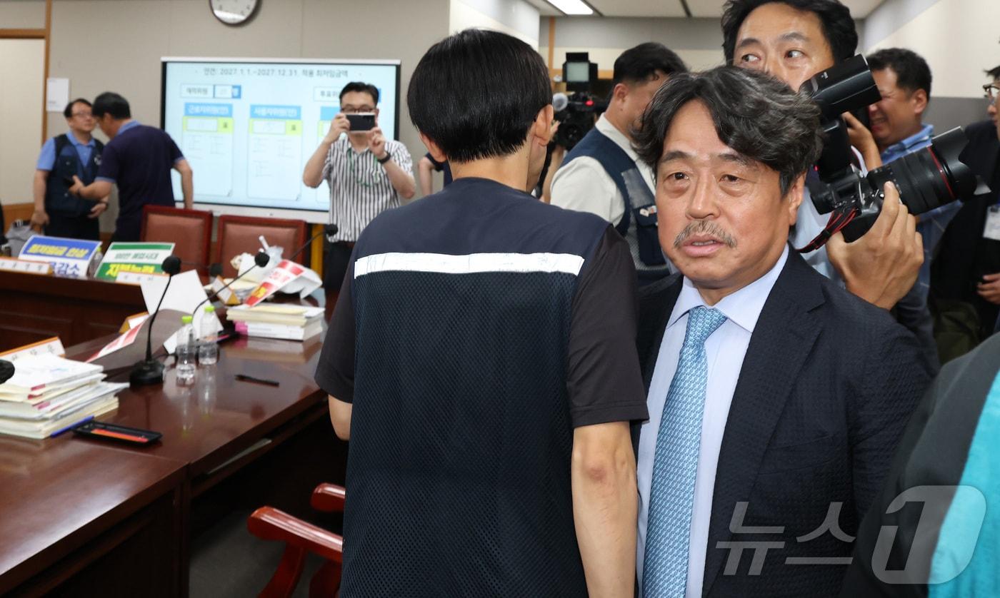 본문 이미지 - 권순원 최저임금위원회 위원장이 14일 세종시 정부세종청사 최저임금위원회에서 열린 2027년도 최저임금위원회 14차 전원회의를 마치며근로자위원들과 인사를 나누려 하고 있다. 2027년도 최저임금이 노·사·공익위원들의 투표로 올해시급 1만320원 보다 380원 오른 1만700원, 3.7% 인상으로 확정 되었다. 2026.7.14 ⓒ 뉴스1 김기남 기자