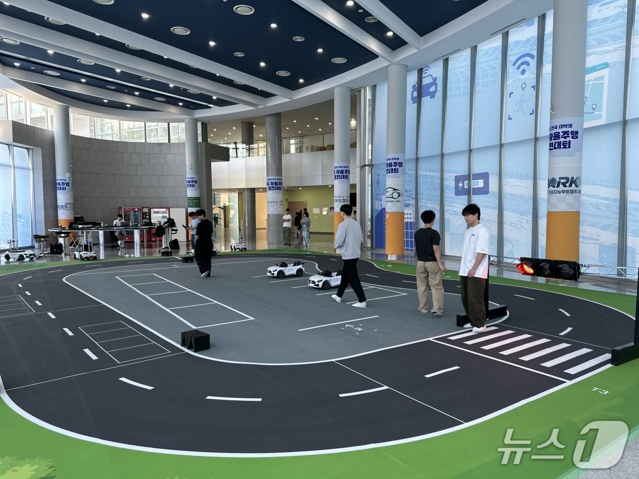 본문 이미지 - '2026년 첨단산업 인재양성 부트캠프 미래차 인공지능(AI) 자율주행 경진대회' 참가 학생들이 자율주행 연습주행을 하고 있다.(교육부 제공)